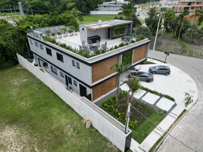 Vista aérea diurna de casa de alto padrão executada na Riviera de São Lourenço, Bertioga · AM&D Engenharia