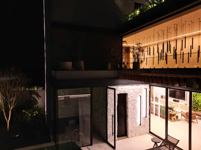 Portal de entrada iluminado de casa de alto padrão na Riviera de São Lourenço, Bertioga · AM&D Engenharia